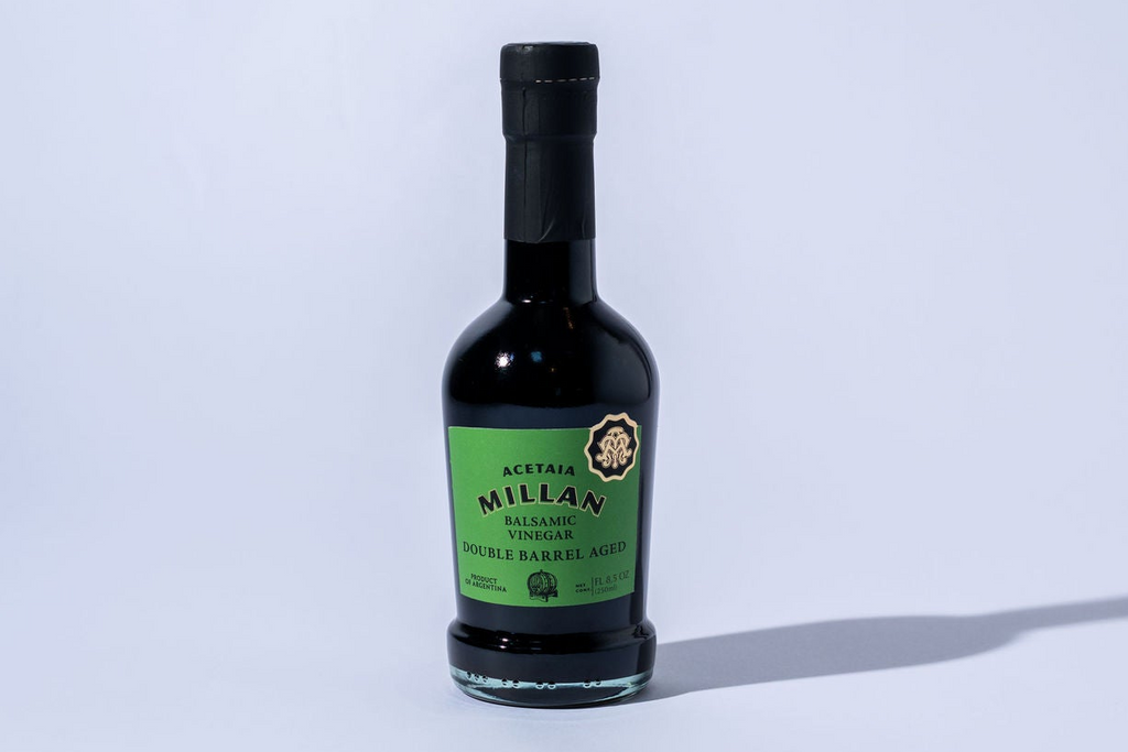 Bottle of balsamic vinegar with a green label on a white background