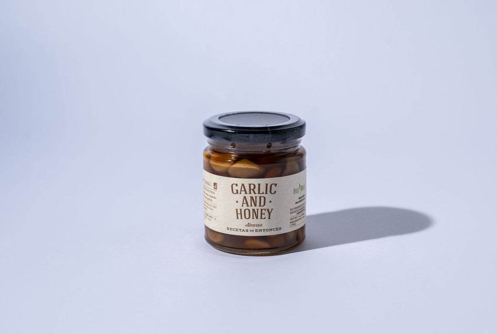 Jar of garlic and honey on a light gray background