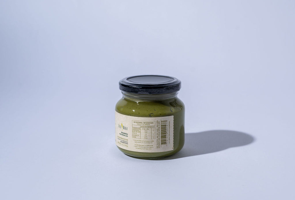 Jar of green olive spread on a light gray background