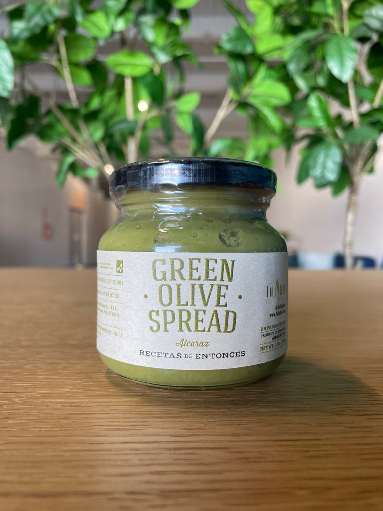A jar of Green Olive Spread, featuring a label that highlights the rich green color and savory nature of the spread