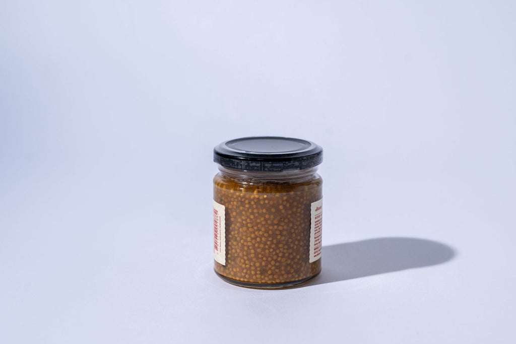 Jar of honey mustard  on a light gray background