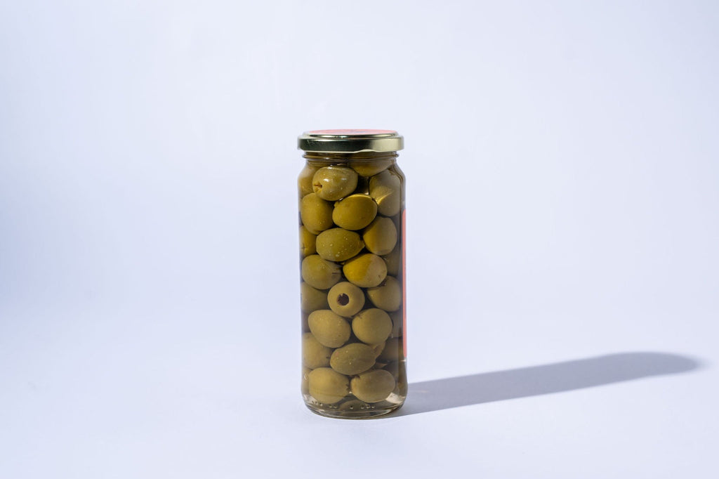 Jar of green olives on a white background