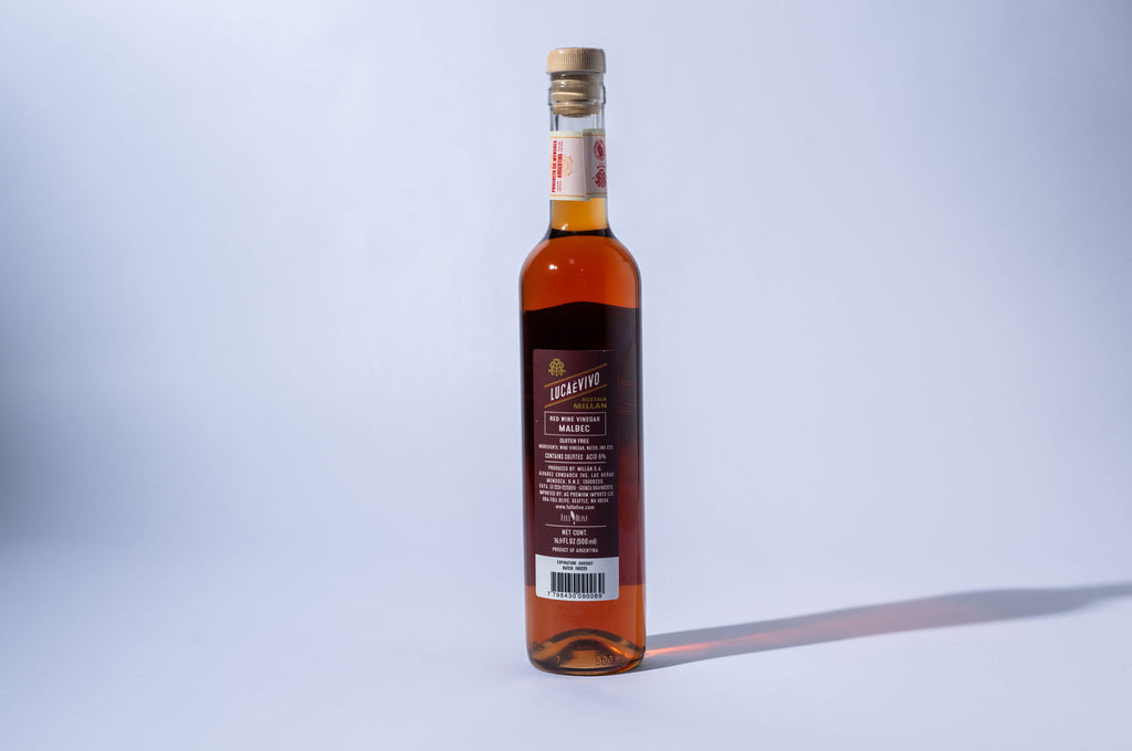 Bottle of red wine with a label on a light gray background