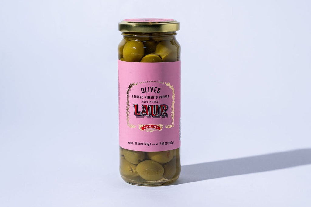 Jar of pickled olives with a pink label on a white background