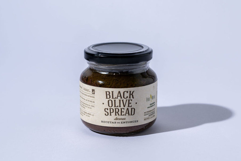 Jar of black olive spread on a light gray background with front label