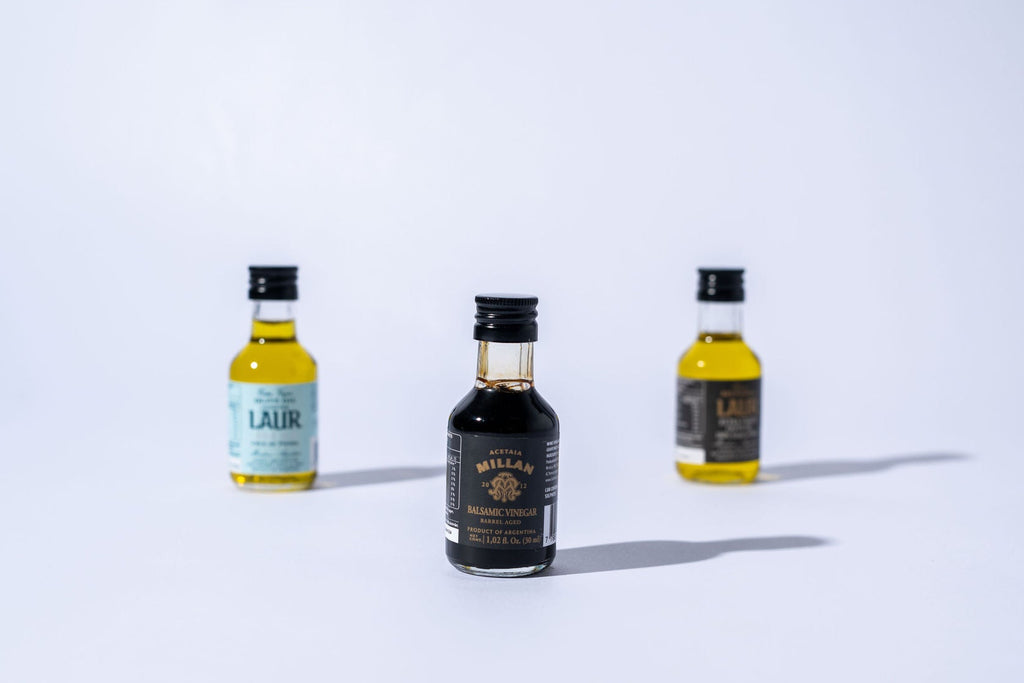 Four small bottles of  vinegar and olive oil on a white background
