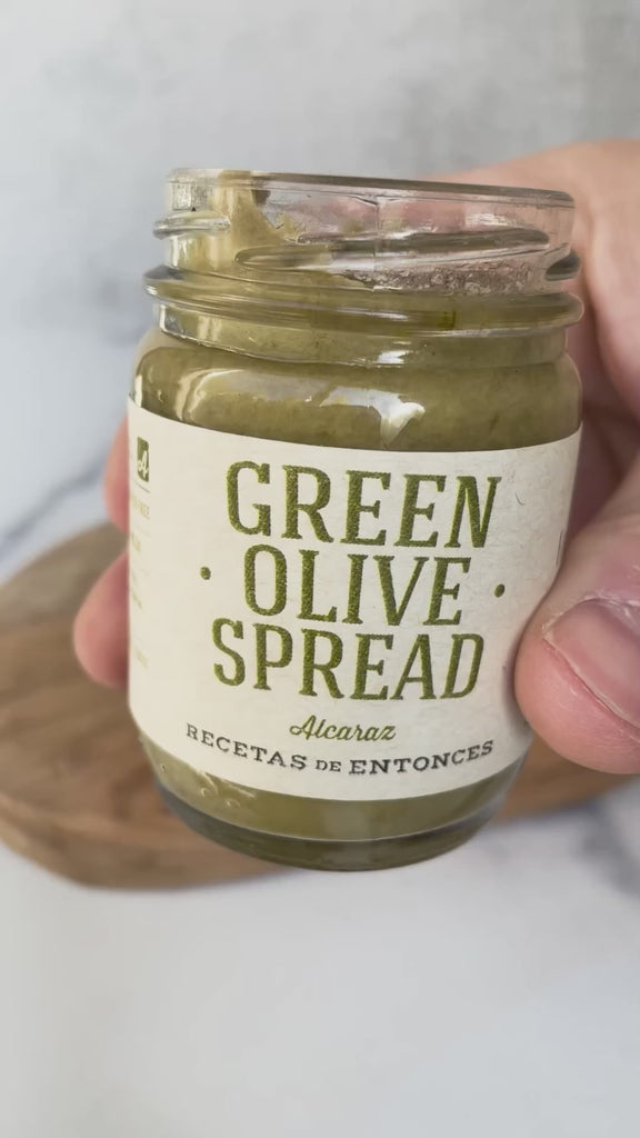 A video of Green Olive Spread, being spread on a cracker highlighting the rich green color and savory nature of the spread