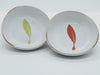 Two Round Porcelain Olive Oil dipping Bowls with the the Full Olive Logo of a olive leaf - on the left green and red on the right